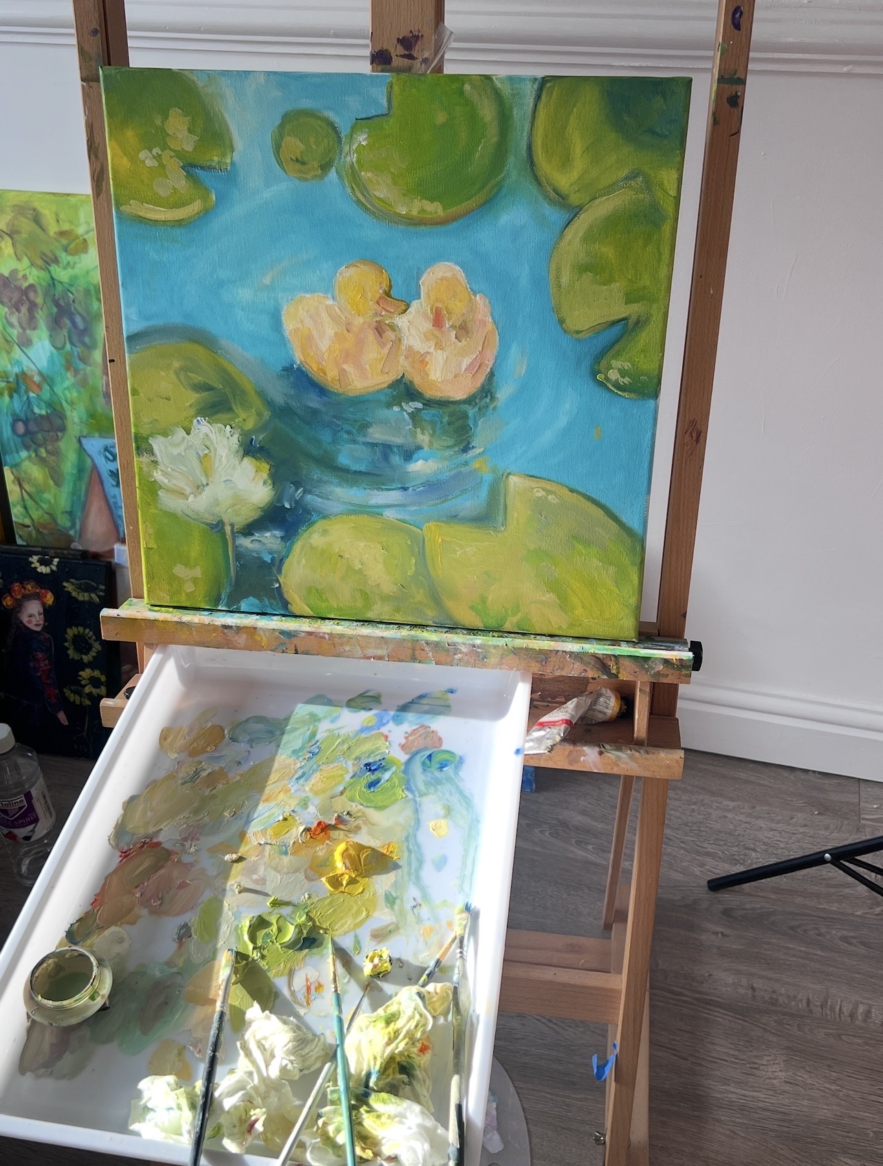 Ducklings in the Garden Pond on the easel during the painting process by Marina Stognieva